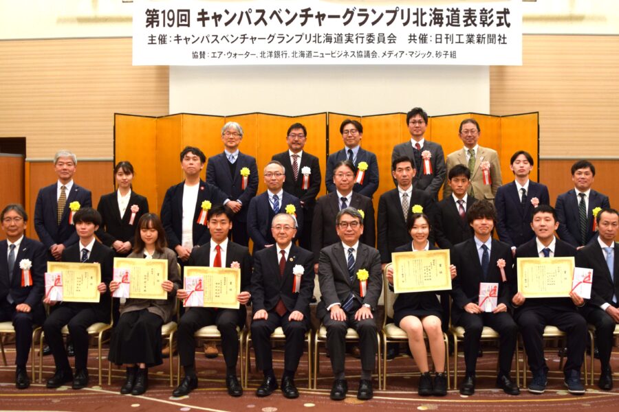 第１９回大会受賞者と藤井裕実行委員長（前列左から５人目）鈴木馨審査委員長（同６人目）および関係者一同